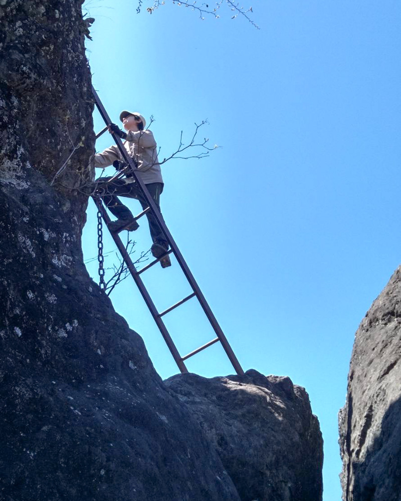 妙義山の岩場でハシゴを登り轟岩を目指す登山風景