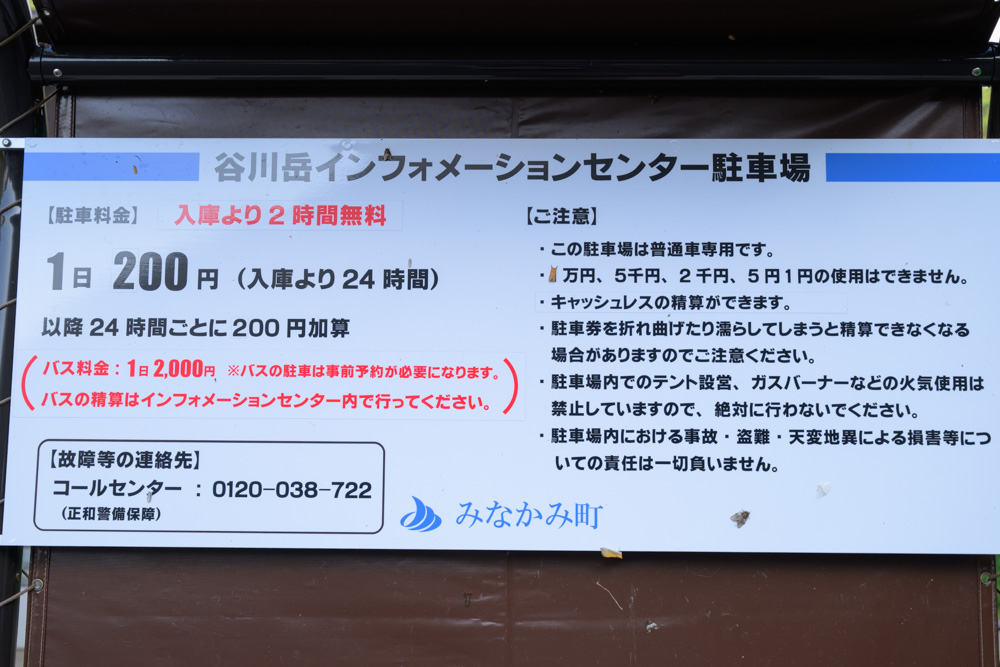 谷川岳インフォメーションセンター駐車場の案内看板。1日200円の駐車料金、注意事項が記載されている