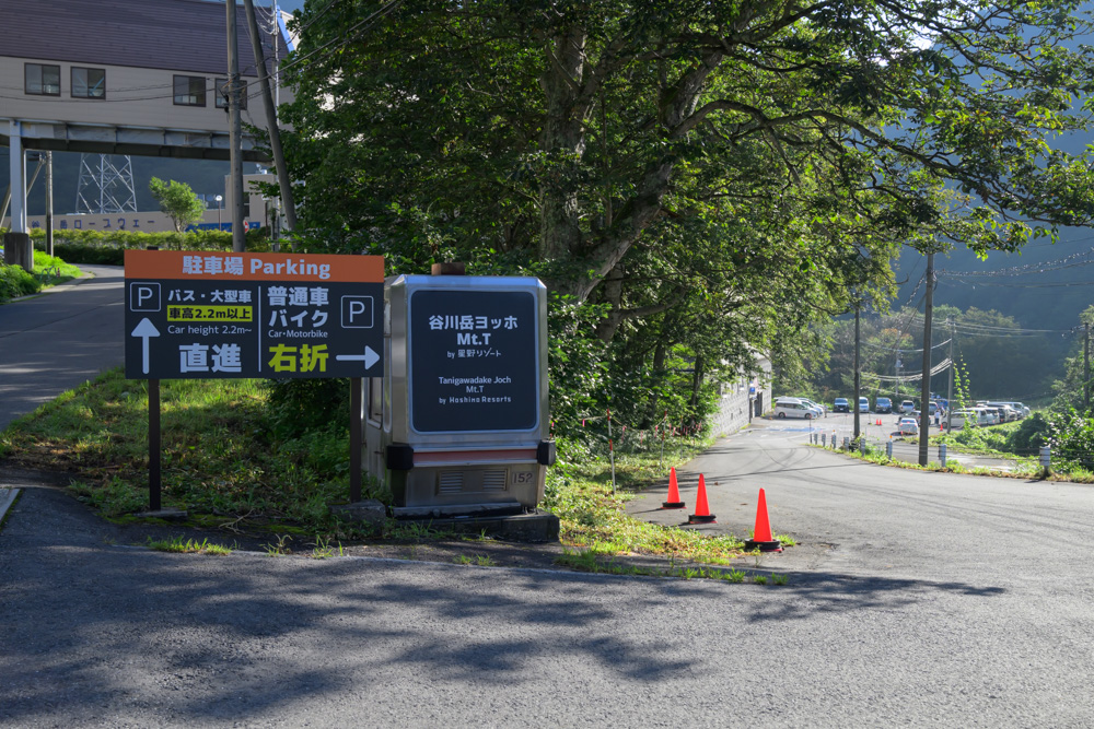 谷川岳ロープウェイ方面の駐車場案内看板。普通車・バイクは右折の案内が出ている