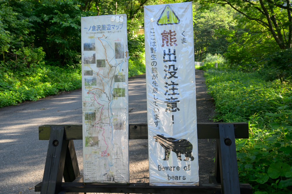一ノ倉沢周辺マップと「熊出没注意」の看板が並んで立っている