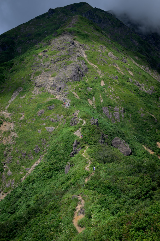 西黒尾根「ラクダの背」を登る登山者たち。急峻な稜線に細い登山道が続いている